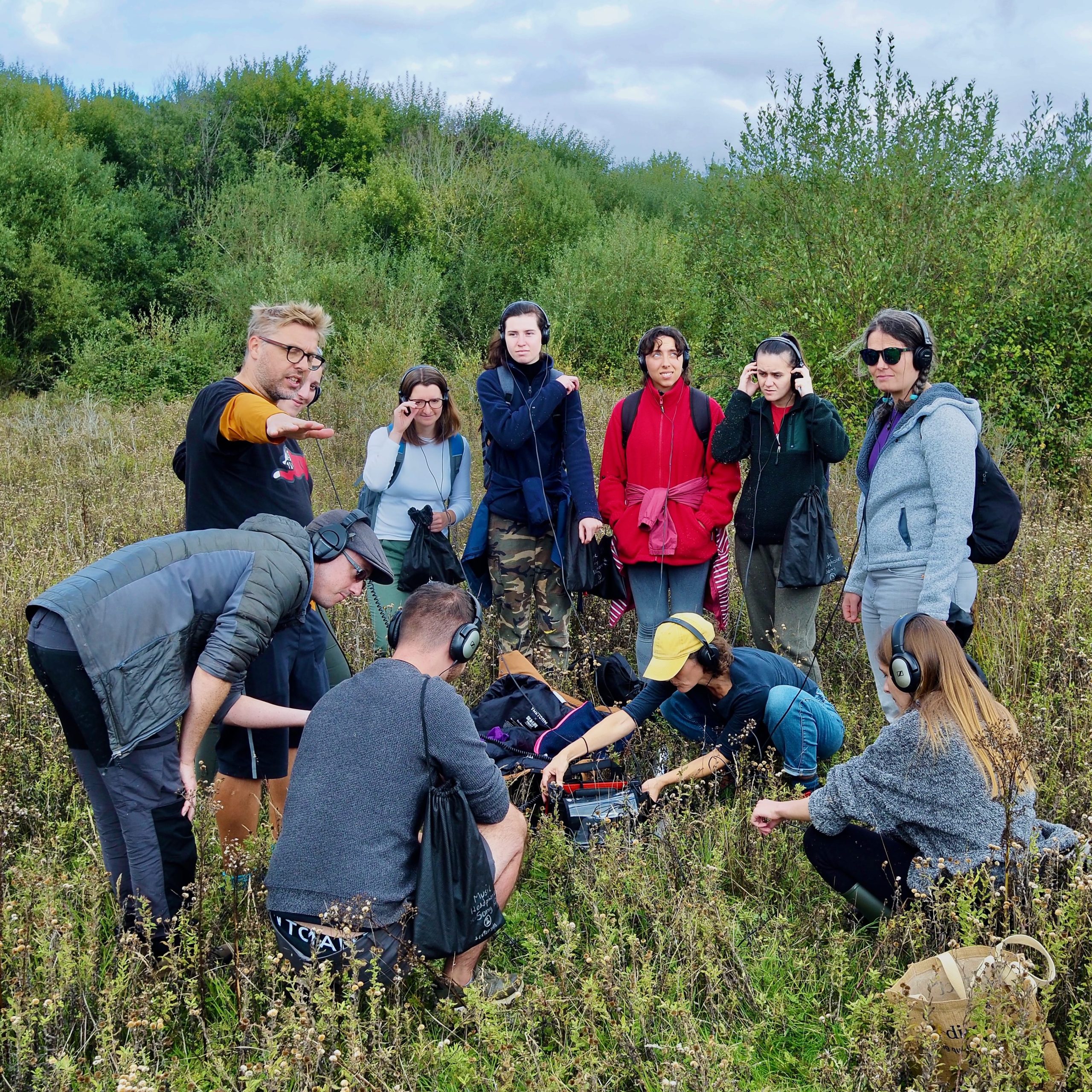 A group of students and researchers listening to the soil using a contact microphone